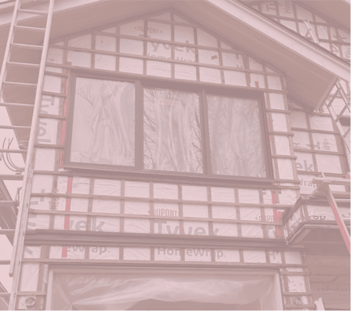 House exterior wrapped in Tyvek with window installation prepared for new siding