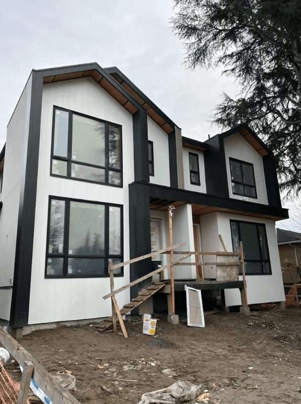 Unfinished modern home with white exterior siding.