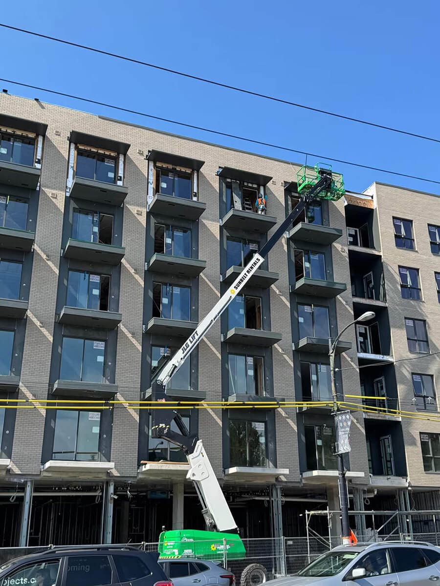 The outside of the Ray building, under construction. There is a crane on the side of the building.